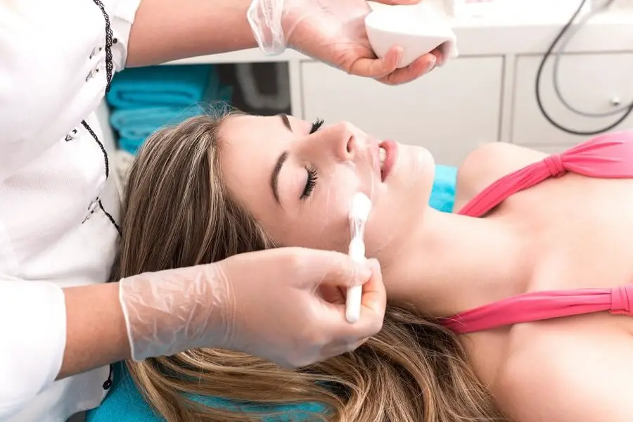doctor applying cream for chemical peel on a patient's face