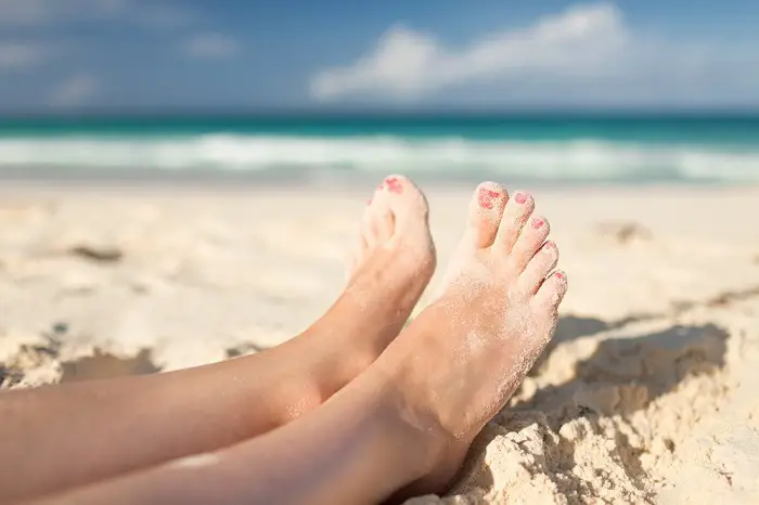 Closeup of woman legs on sea shore