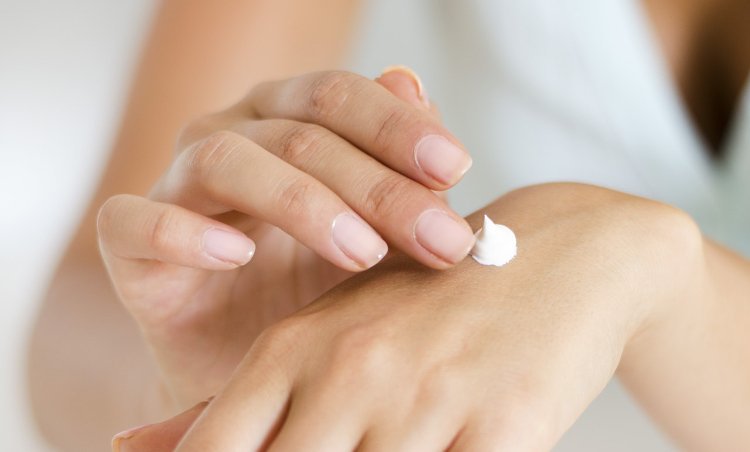 woman applying cream on her hand