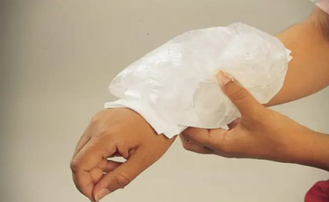 woman applying cold compress on wound
