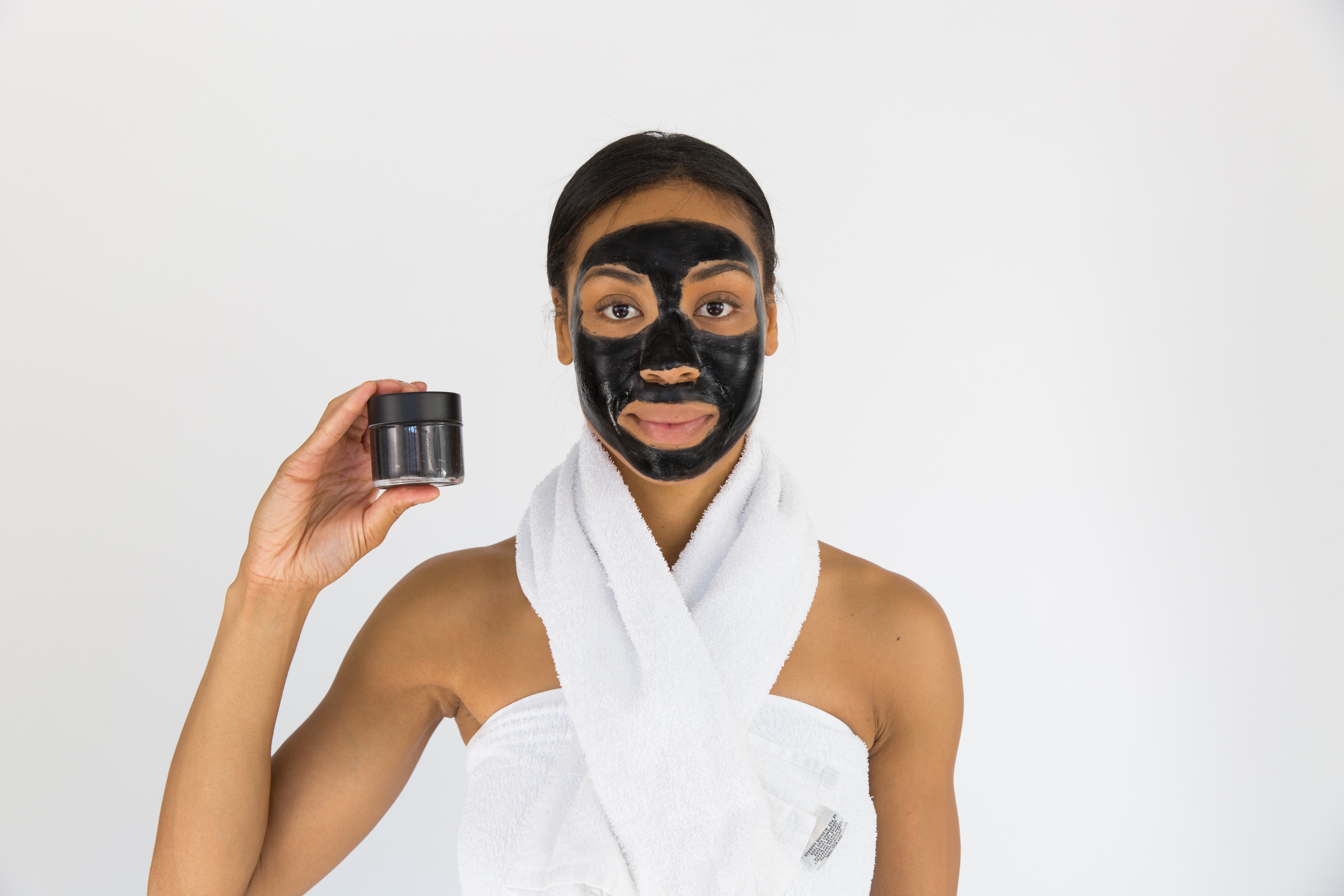 Girl with a Black facial mask was holding a product