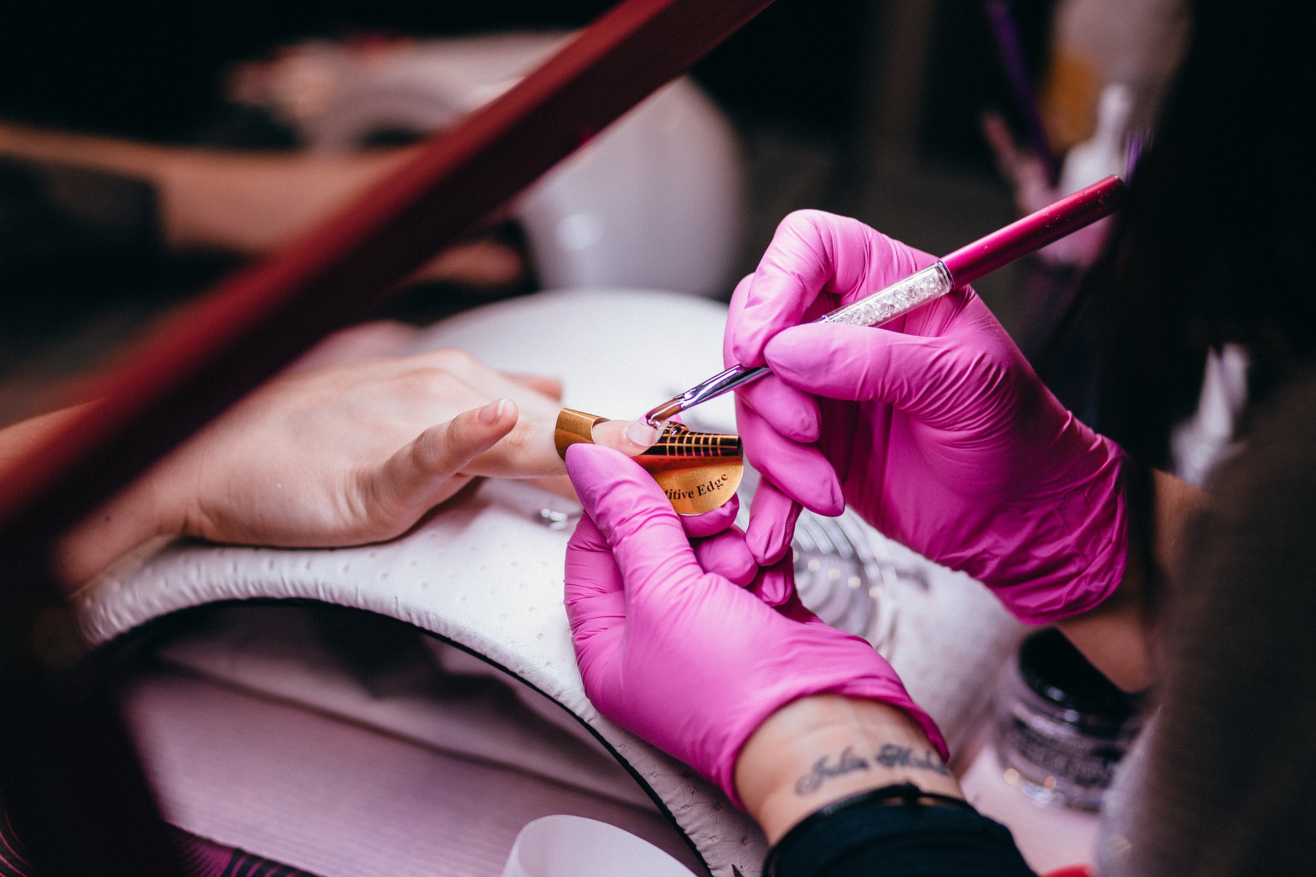 Girl with Purple Gloves Putting some Cuticle Cream with Her Customer